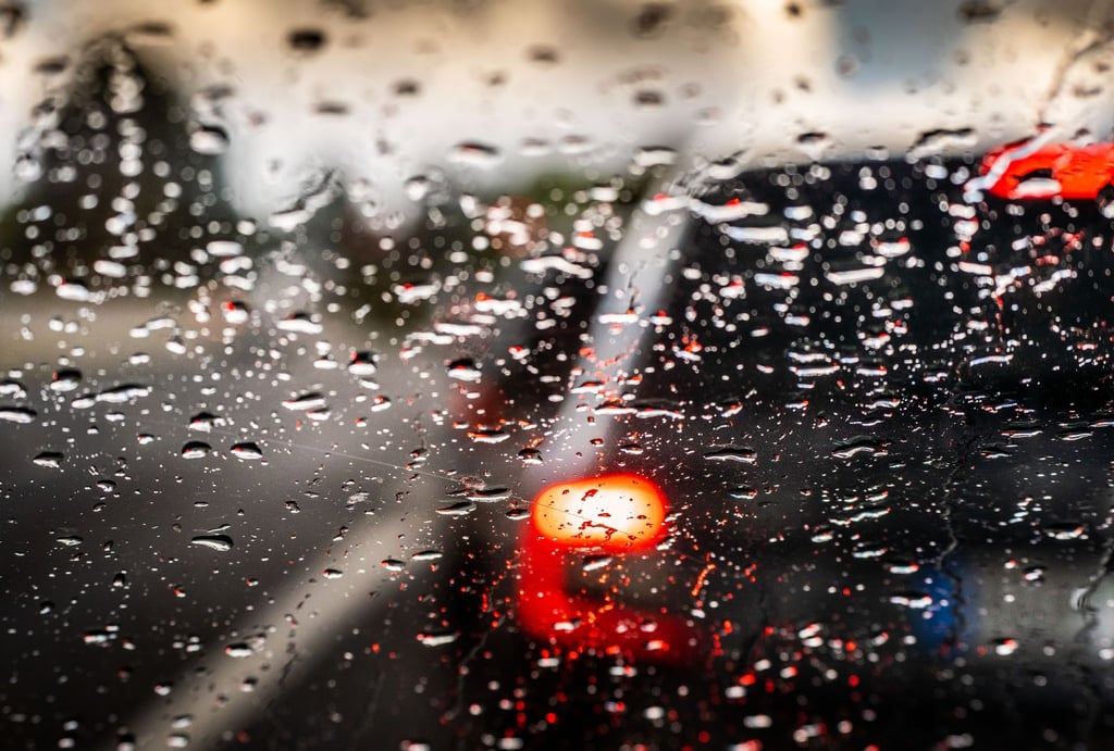 Regentropfen liegen auf einer Windschutzscheibe.