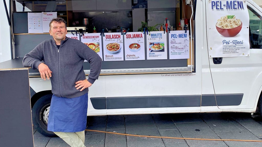 Vladislav Sidorov steht mit seinem Imbisswagen auf dem Marktplatz in Halle.