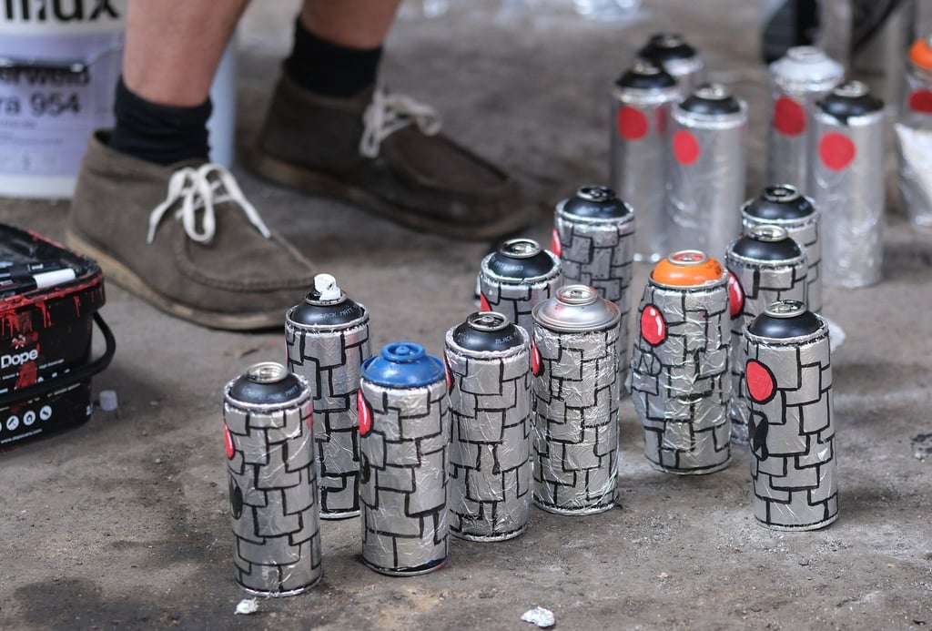 Spraydosen stehen auf dem Boden einer Industriehalle - Austragungsort der "iburg 2023", Festival für urbane Kunst.