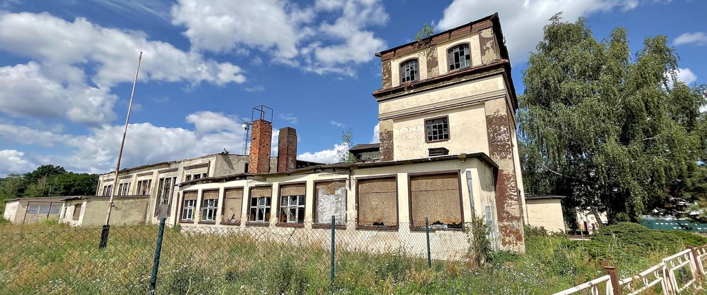 Blick auf die noch auf dem Gelände des ehemaligen Bahnbetriebswerkes Jerichow stehenden Gebäude. Sie sind von einem Zaun umgeben. Die Türen sind verschlossen.