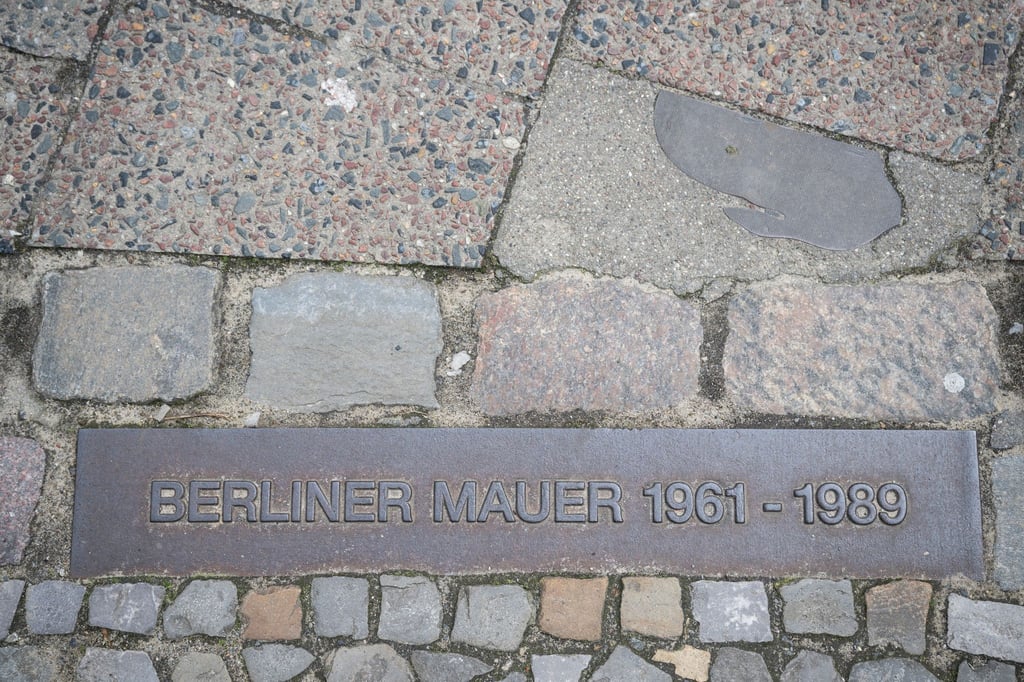 Eine Markierung verweist auf den ehemaligen Verlauf der Mauer in Berlin.