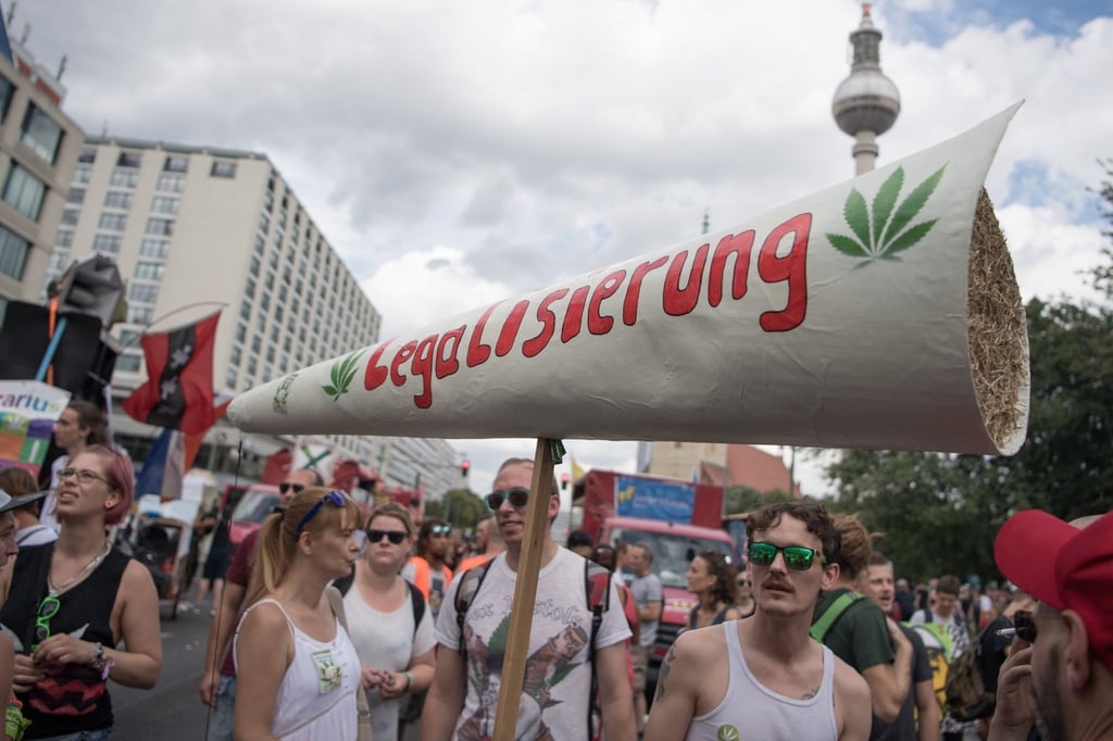 Teilnehmer halten einen riesigen Joint mit der Aufschrift „Legalisierung“.
