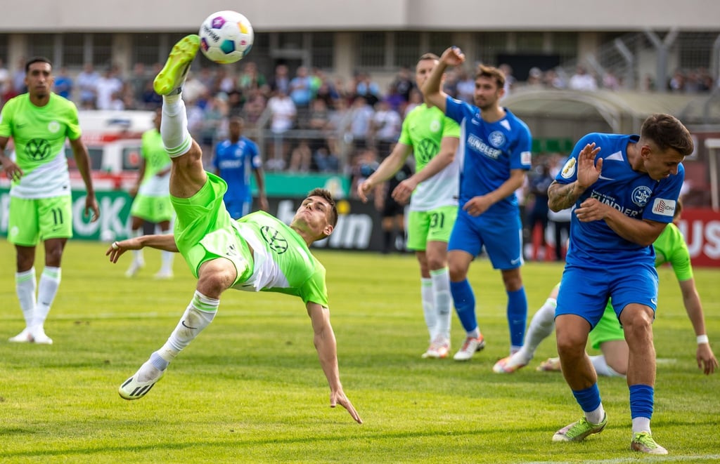 Wolfsburgs Joakim Maehle (l) netzt den Ball mittels Fallrückzieher ein.