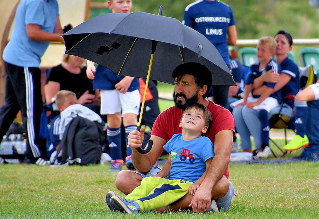 Der kleine Luis fand den großen Schirm viel spannender, als das Spiel. Dabei kickte gerade sein großer Bruder auf dem Rasen.