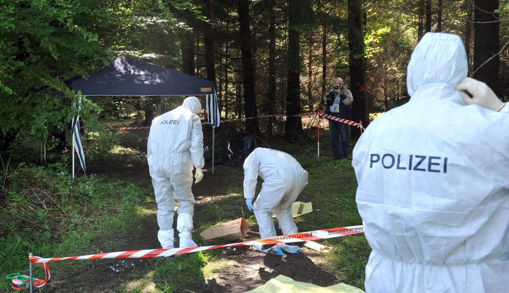Kriminalbeamte untersuchen im Juni 2010 bei Heidenheim-Nietheim den Waldboden.