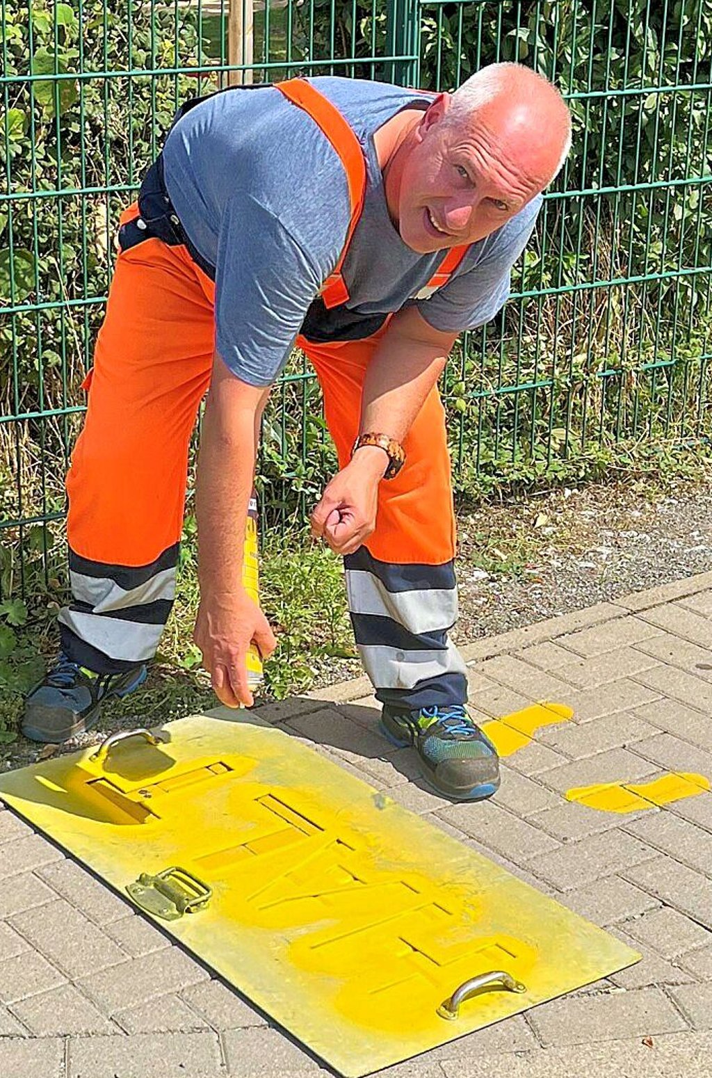 Matthias Schupp vom Bauhof erneuert die gelben Füße auf Gehwegen in Wernigerode.