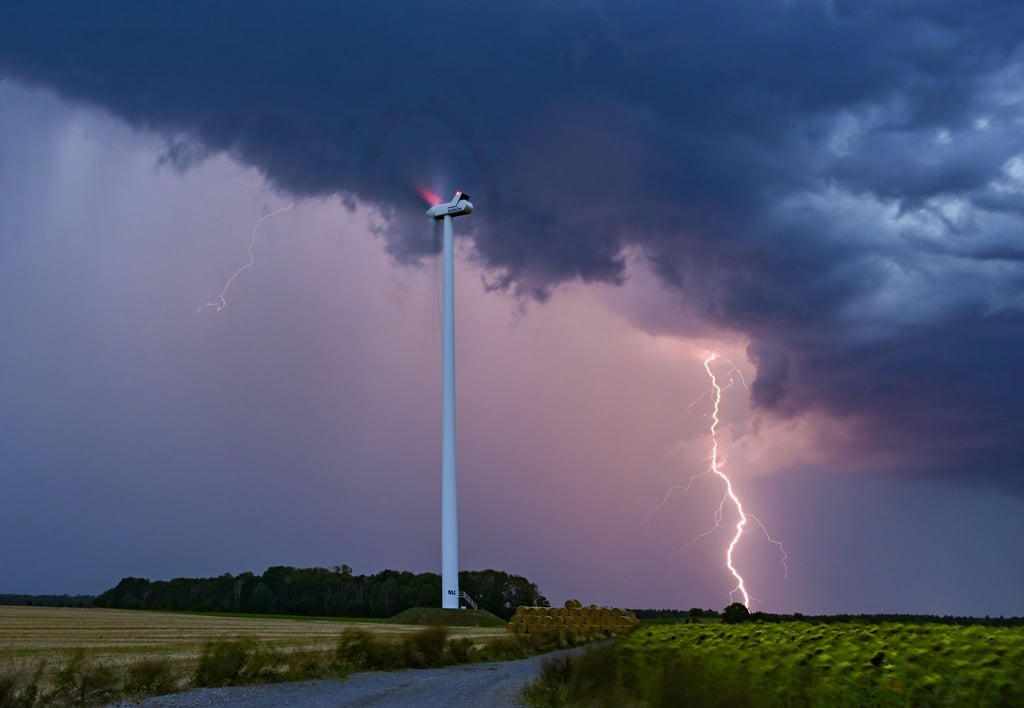 Ein Blitz leuchtet am Abendhimmel hinter einer Windenergieanlage im Osten Brandenburgs.