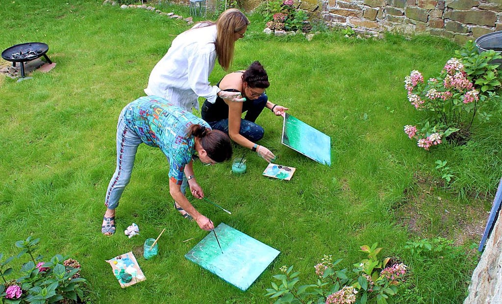 Der kleine Garten hinterm Haus bietet sich ebenfalls zum Malen an. Einige Frauen probierten es gleich einmal aus.
