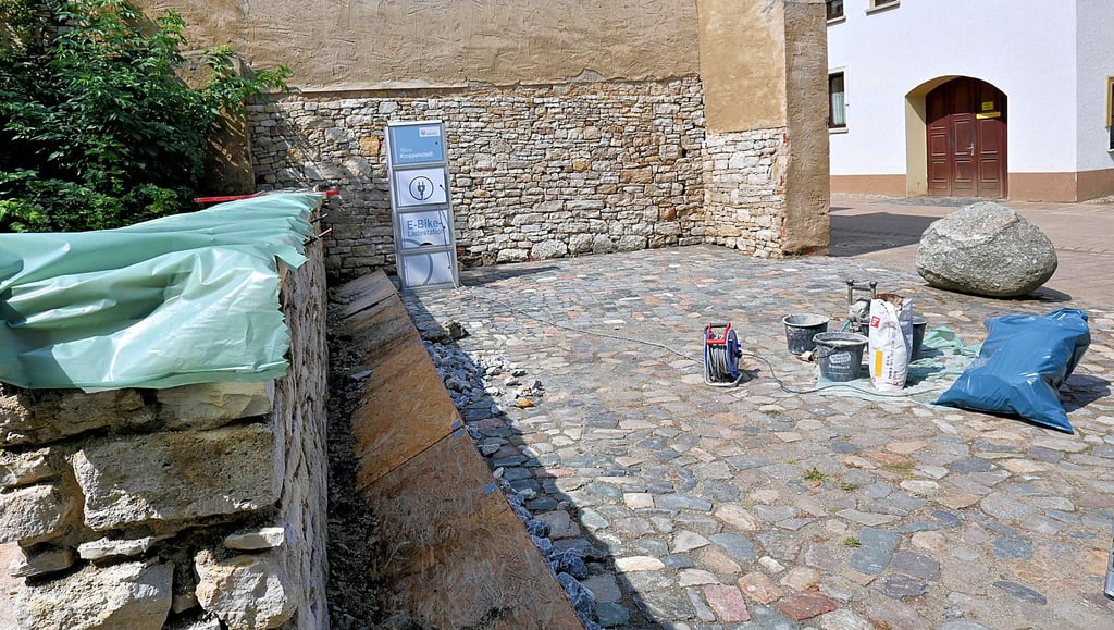 Die in die Jahre gekommene Sandsteinmauer an der Kroppenstedter Grundschule sowie eine angrenzende Gebäudewand werden saniert. Neben der Ladesäule würde sich eine Bank gut machen.