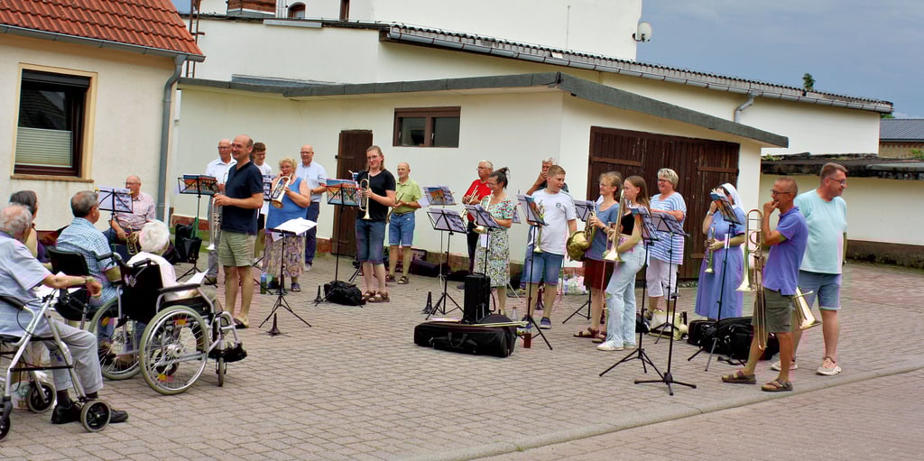 Klassische Kirchenlieder und modernere Stücke werden unter der Leitung von Carsten Miseler auf der Sommertour des Bläserchors der Schönebecker Kirchengemeinde zum Besten gegeben, hier vor der Dorfkirche St-Martin in Eggersdorf.