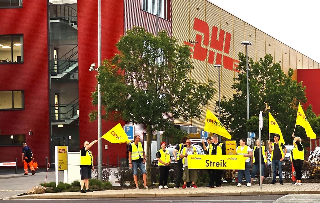 Mitarbeiter stehen während eines Warnstreiks vor dem DHL Hub Leipzig.
