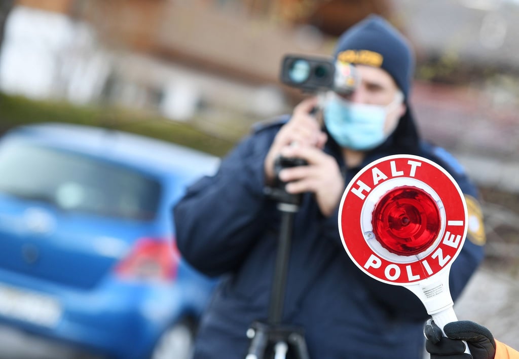 Polizisten blitzen ein Auto mit überhöhter Geschwindigkeit.