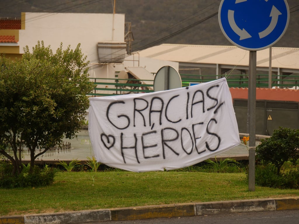 Ein Banner mit der Aufschrift „Gracias, Heroes“ (Danke, Helden) ist an einem Kreisverkehr gespannt.