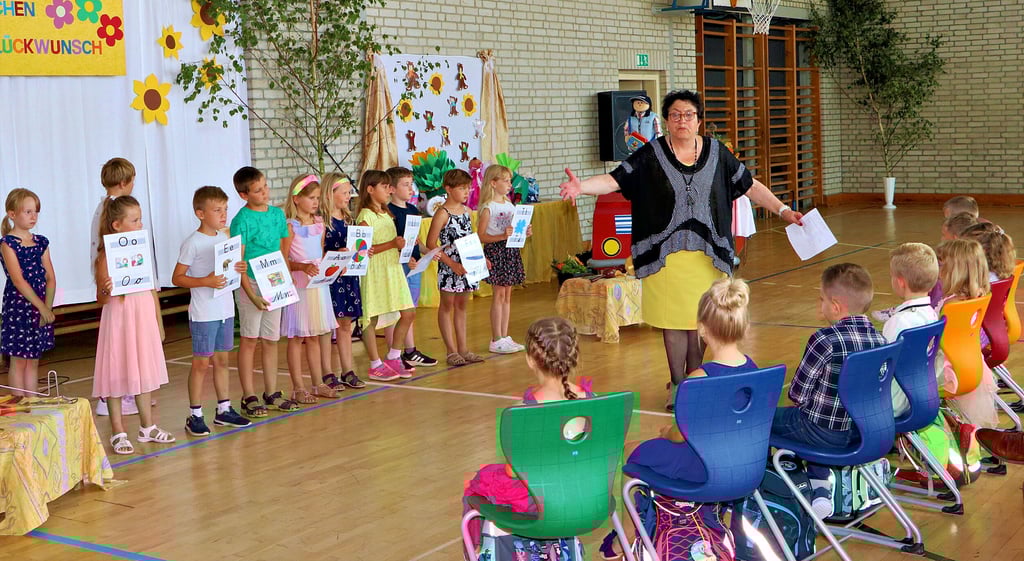 Dort ist sie am liebsten: Ingrid Mehlhorn zwischen den Schülern, rechts die neue erste Klasse, links die Zweitklässler, die das Programm zur Einschulung in Seydas Turnhalle aufführen.