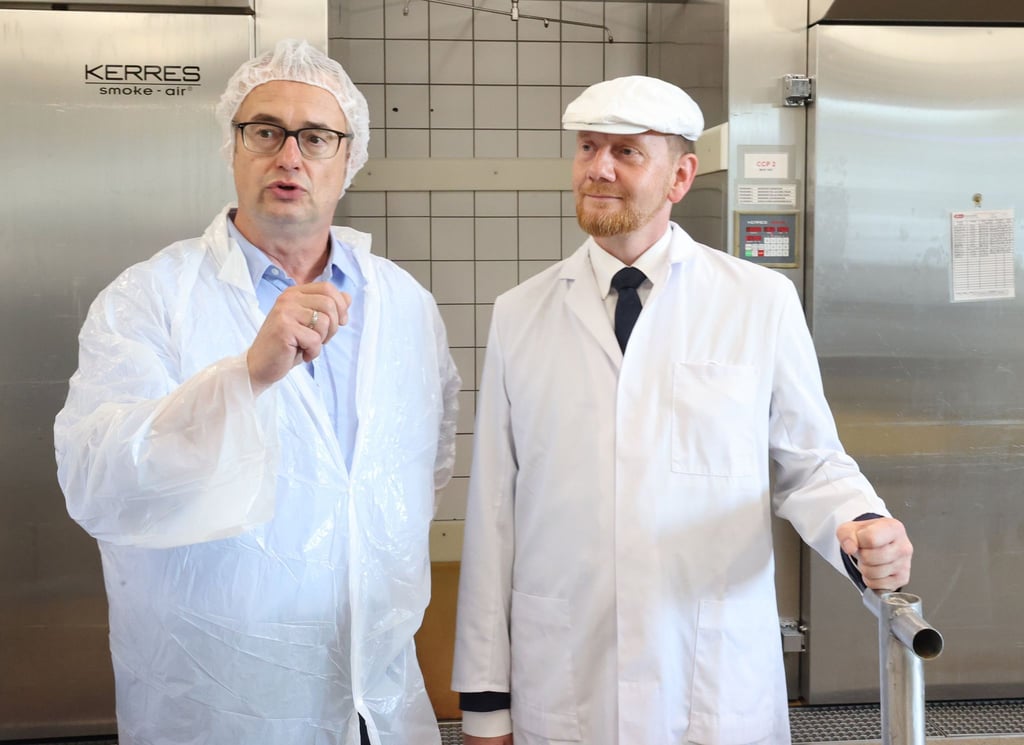 Michael Kretschmer (r, CDU), Ministerpräsident von Sachsen, mit Herrn Schmidt, Inhaber eines Betriebs.