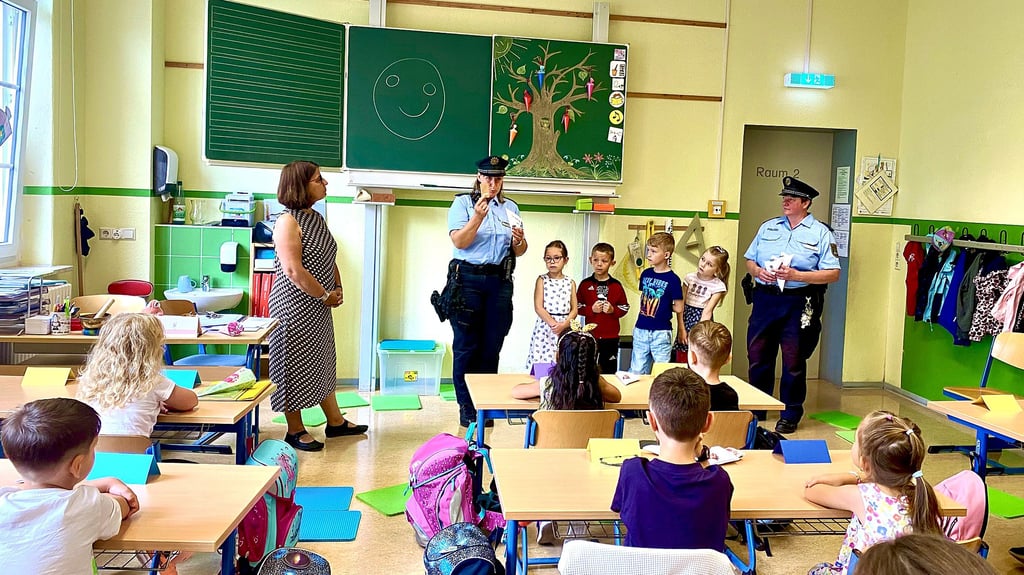 Die Regionalbeamtinnen Peggy Kutzner (links) und Ina Lehmann überreichen Zuckertüten an Schülerinnen und Schüler der Klasse 1b.