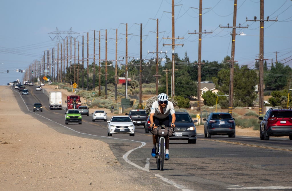 Der deutsche Athlet Jonas Deichmann fährt mit seinem Fahrrad eine Straße in den USA entlang.