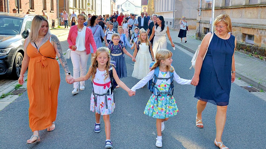 Eingerahmt von ihren künftigen Lehrerinnen gehen die Langenweddinger Einschüler von der Kita zur Sporthalle.