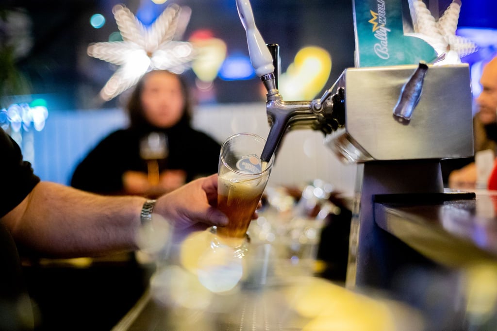 Ein Kneipenwirt zapft in einer Gaststätte Bier.