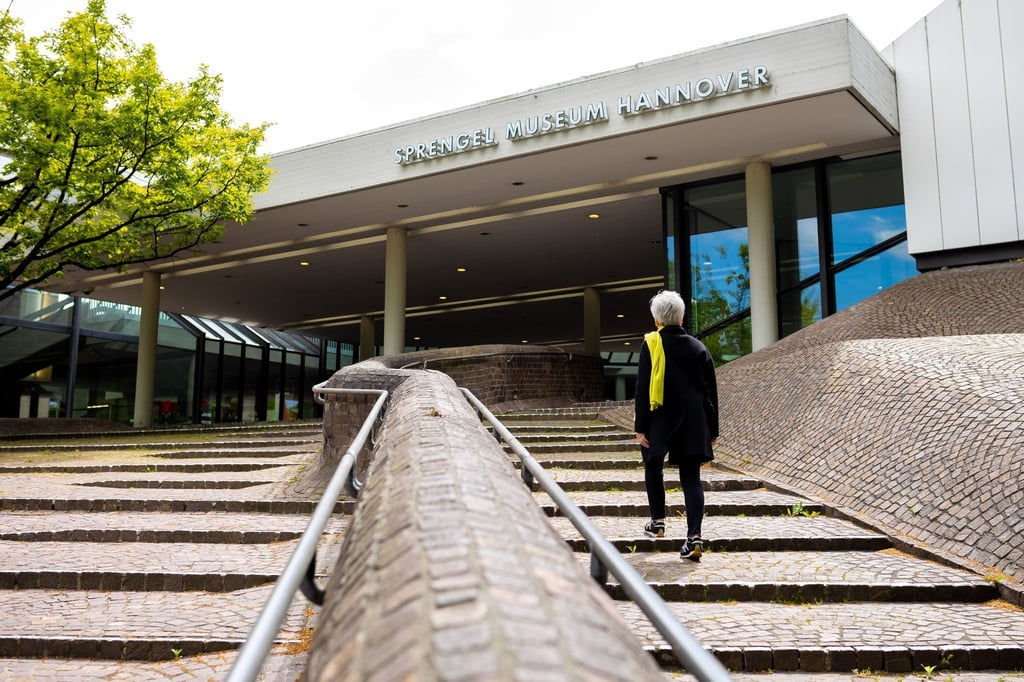 Eine Besucherin geht auf den Eingangsbereich vom Sprengel Museum in Hannover zu.