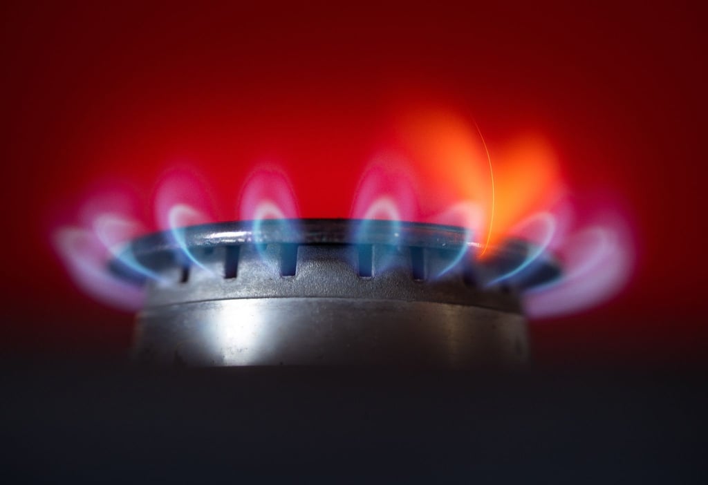 Die Flamme eines Gasherdes brennt in einer Küche.
