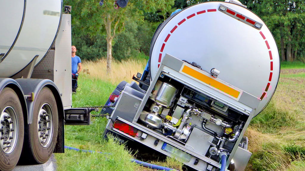 Das dauert: Aus dem Laster, bei der Bismark im Kreis Stendal in den Sraßengraben gerutscht war, wird mit Spezialtechnik Milch in ein anderes Tankfahrzeug umgepumpt.