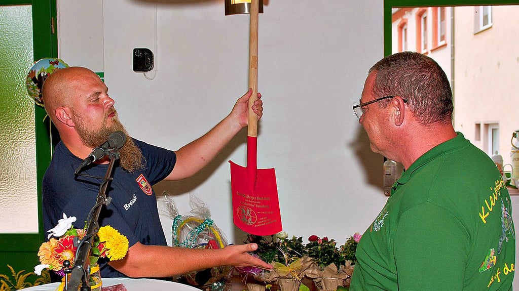 Im Namen der Freiwilligen Feuerwehr überreicht Michael Brausch (links) einen gravierten Spaten an den Kleingartenverein.