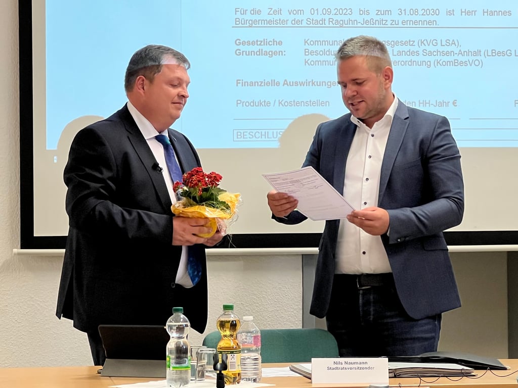 Hannes Loth (AfD) wird vom Stadtratsvorsitzenden Nils Naumann (r.) als neuer Raguhn-Jeßnitzer Bürgermeister vereidigt.