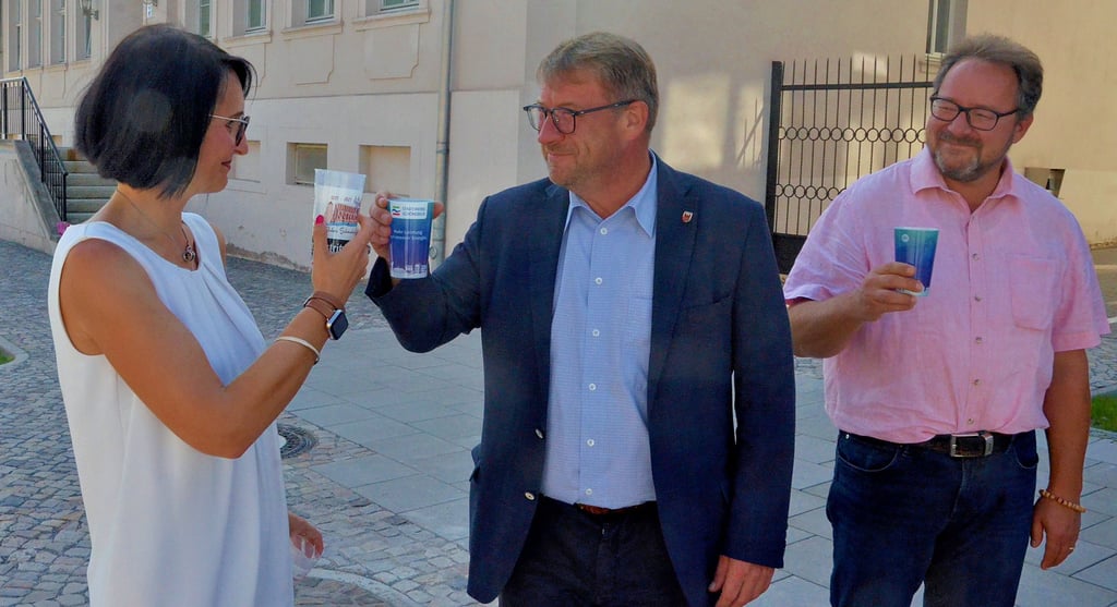 Mit dem Wasser aus dem neuen Trinkwasserbrunnen stoßen Oberbürgermeister Bert Knoblauch und Julia Teige von den Stadtwerken Schönebeck an. Seit Mittwoch können Schönebecker im Breiteweg frisches Trinkwasser zapfen.