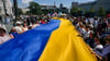 Menschen halten eine riesige ukrainische Fahne während einer Kundgebung in Belgrad zum 32. ukrainischen Unabhängigkeitstag.