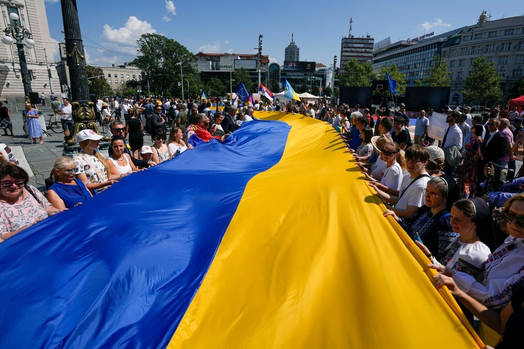 Menschen halten eine riesige ukrainische Fahne während einer Kundgebung in Belgrad zum 32. ukrainischen Unabhängigkeitstag.