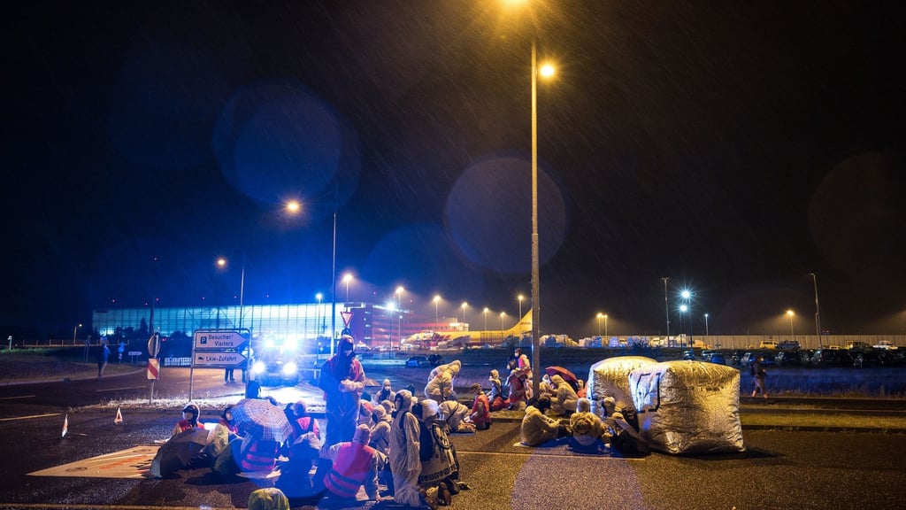 Aktivisten der Initiative "CancelLEJ" blockieren eine LKW Zufahrt des DHL-Terminals.
