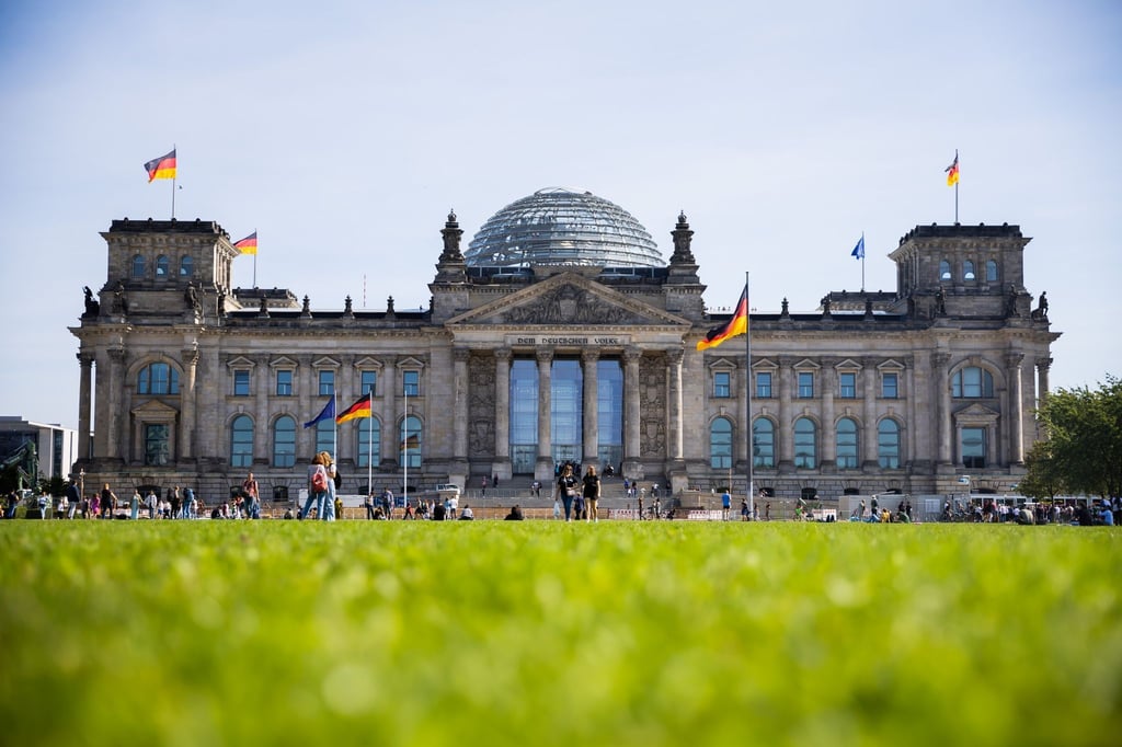 Vor und auf dem Reichstagsgebäude wehen Fahnen.