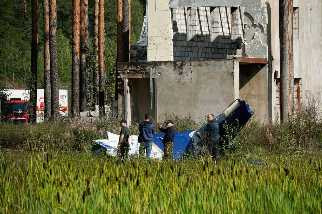 Russische Soldaten inspizieren ein Teil eines abgestürzten Privatjets bei Kushenkino.