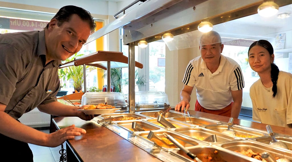 Koch und Inhaber Viet Vuong Do und seine Tochter richten das abendliche Buffett, an dem sich Redakteur Mike Fleske seinen Speisenteller zusammenstellt.