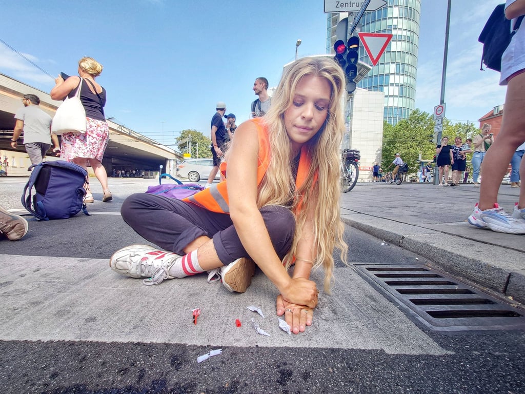 Klimakleberin blockiert Fahrbahn.