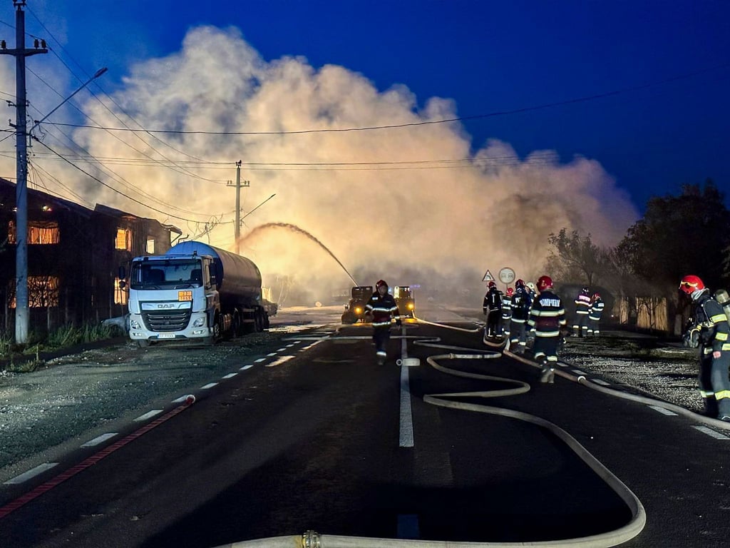 Feuerwehrleute bei Löscharbeiten nach einer Explosion an einer Tankstelle für Flüssiggas (LPG).