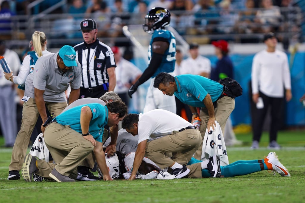 Wide Receiver Daewood Davis (am Boden) von den Miami Dolphins wird direkt nach seiner Verletzung untersucht.