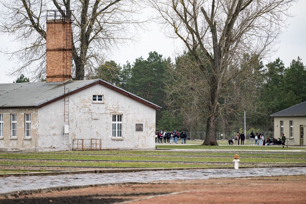Personen laufen in der Gedenkstätte Sachsenhausen über das Gelände des ehemaligen Konzentrationslager.