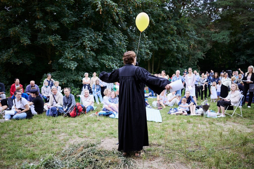 Eine Pastorin begrüßt die Gäste beim Tauffest der Evangelischen Kirche.