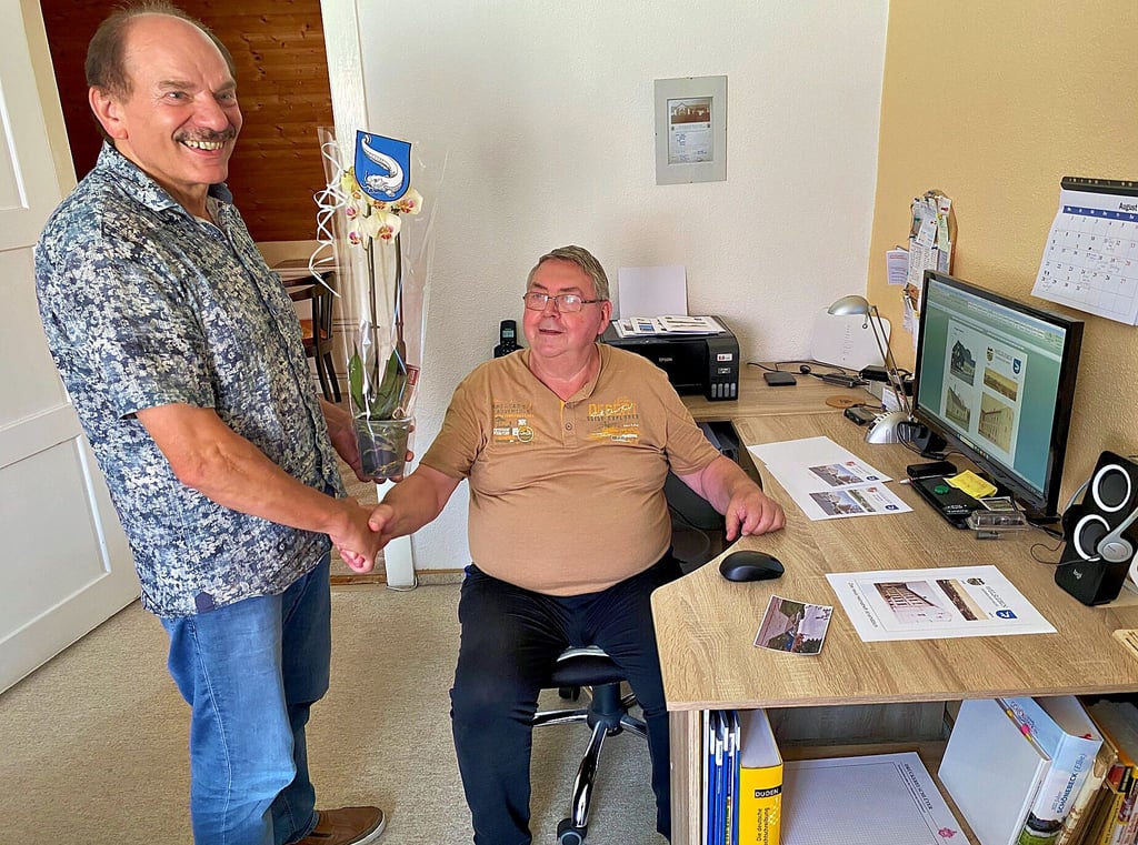 Das Geburtstagskind Elmar Ziegler (r.) in seinem Arbeitszimmer. Hier entsteht das Heimatheft. Neben Glückwünschen und Dank überbringt Hans-Jürgen Korn zudem eine Blume mit Dorfwappen.
