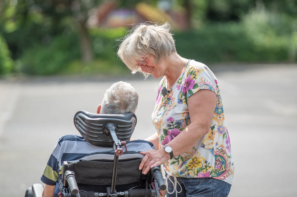 Hilde (60) zu Besuch bei ihrem Mann. Er sitzt seit seinem Unfall im Rollstuhl.
