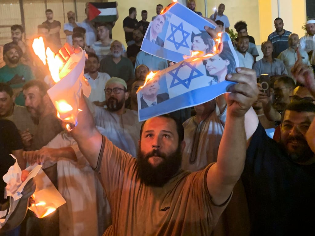 Menschen verbrennen in Tripolis Bilder, die den israelischen Außenminister Eli Cohen und seine libysche Amtskollegin Nadschla al-Mankusch zeigen.