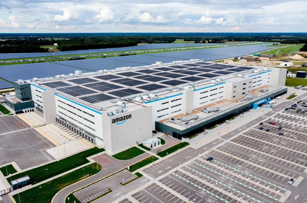 Autos stehen auf einem Parkplatz vor dem neuen Logistikzentrum von Amazon in Großenkneten.