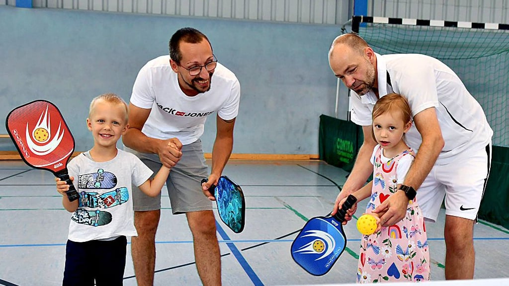 Pickleball ist eine in den USA entstandene Ballsportart, die Elemente des Badminton, Tennis und Tischtennis verbindet. Björn Boßmann vom Vorstand der SG zeigt Denni Nitschke und dessen Kinder Lisa und Lars, wie gespielt wird. Jeden Sonntag von 16 bis 18 Uhr wird trainiert.