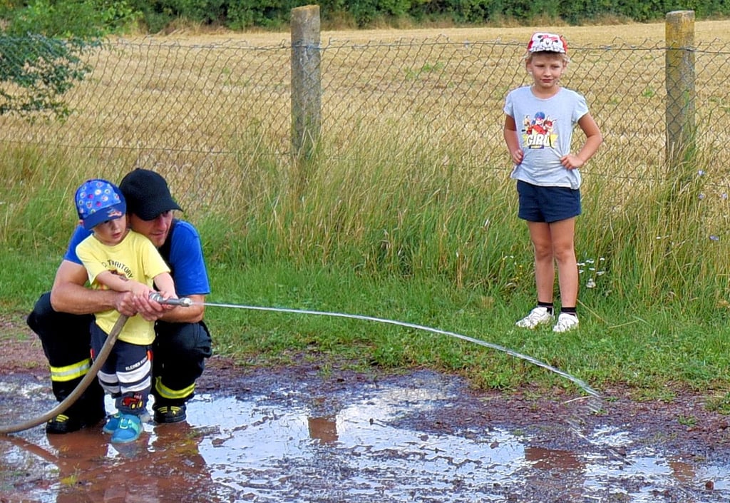 Der zweijährige Oskar übte mit seinem Papa wie man mit einer Wasserspritze umgeht.