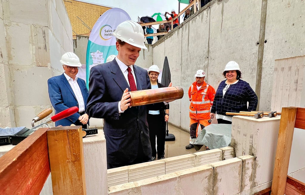 Björn Bühler, Ärztlicher Direktor des Bernburger Maßregelvollzuges, legt eine Kassette mit Dokumenten ins Fundament des Neubaus.