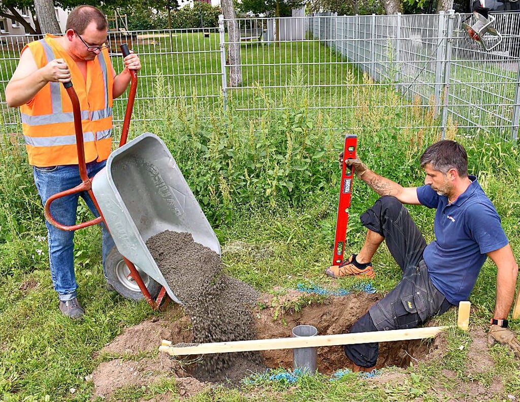 Daniel Pilz von Sport-Thieme (r.) unterstützte die Ehrenamtlichen, hier Rainer Grußka vom FanRat, beim Bolzplatzbau in Magdeburg-Cracau.