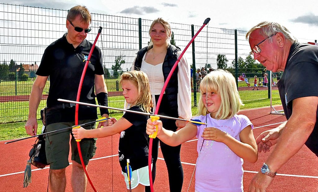 Lia und Alina (vorn) probieren sich im Bogenschießen aus. Laura-Sophie begleitet die Siebenjährigen, die in Grauingen zuhause sind. Die Bogenschützen Torsten Bayer (l.) und Wilfried Rähse geben Anleitungen.