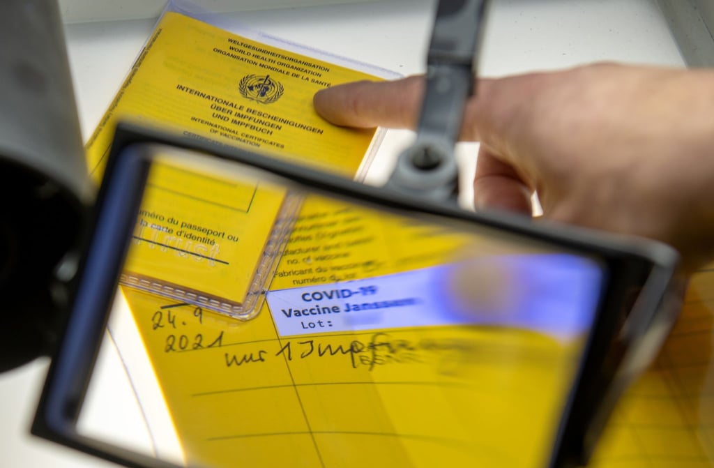 Bei der Kriminalpolizeiinspektion liegen Impfpässe unter einer Lupe.